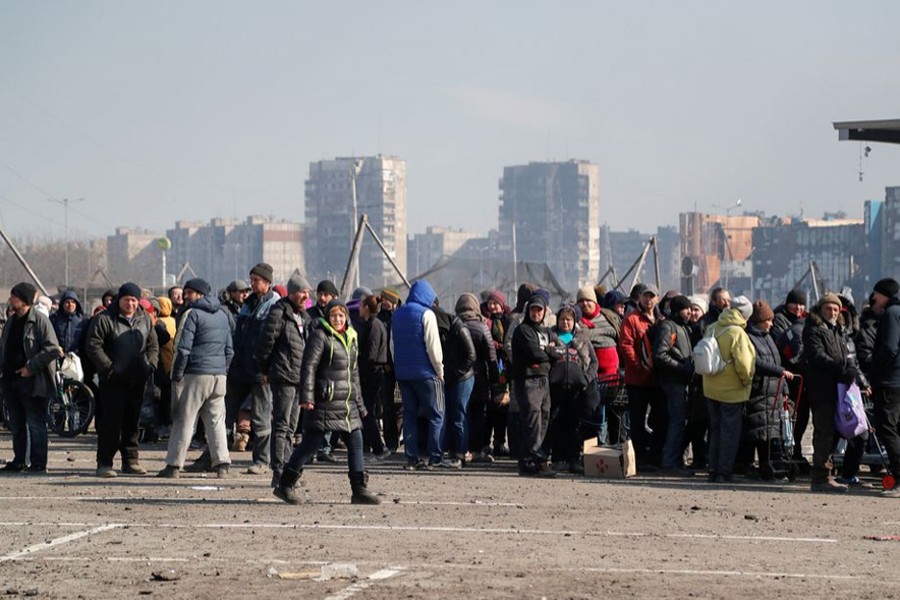 People stand in a long queue during the distribution of humanitarian aid near a damaged store of wholesaler Metro in the course of Ukraine-Russia conflict in the besieged southern port city of Mariupol, Ukraine on March 24, 2022 — Reuters photo