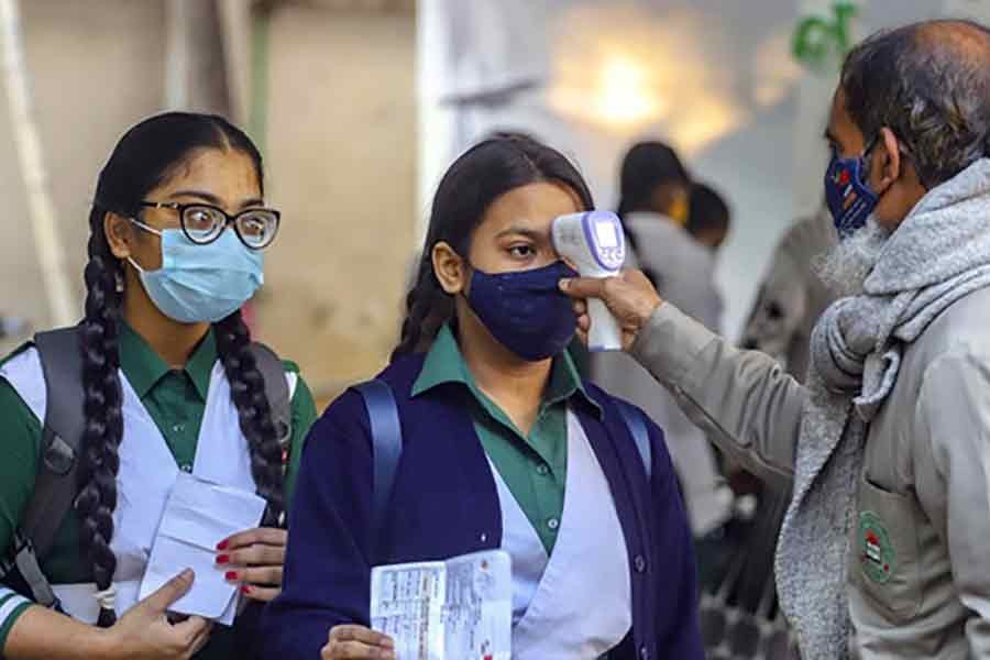 Authorities measuring the body temperature of students before letting them into Rayer Bazar High School in Dhaka recently –bdnews24.com file photo