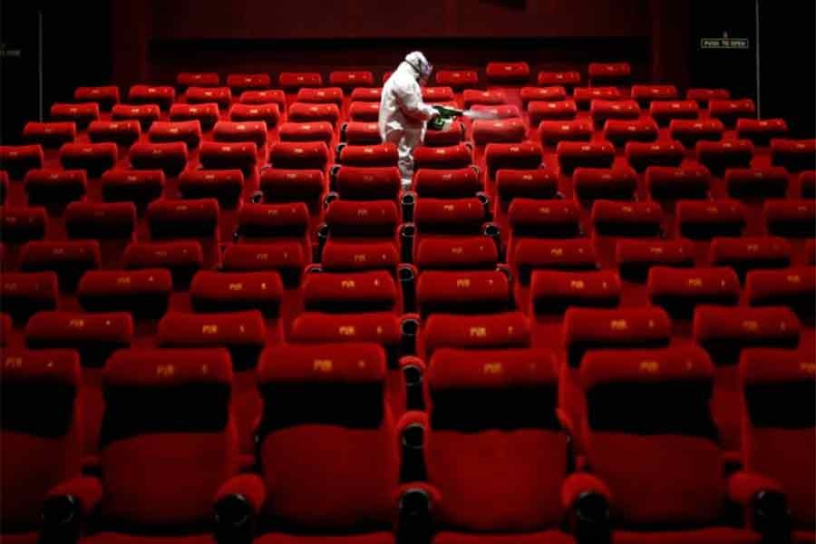 A worker spraying disinfectant inside an empty PVR multiplex in New Delhi of India on July 31 in 2020 –Reuters file photo