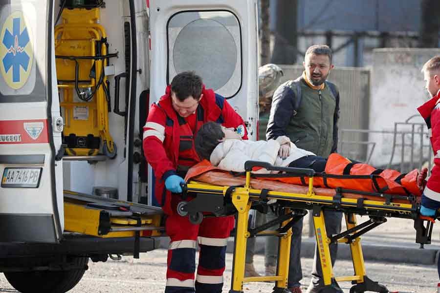 Medical specialists transporting a woman, who was wounded in the shelling of an apartment building, to an ambulance in Kyiv of Ukraine on February 26 –Reuters file photo