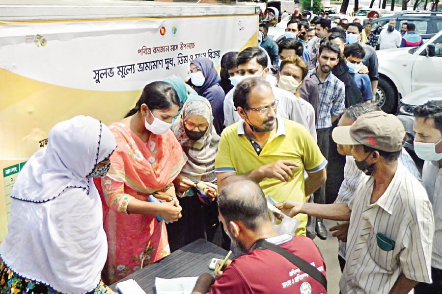 People in their large numbers stand in a long queue to get serial numbers so that they can buy beef, mutton, broiler chicken, milk and eggs at subsidised rates from a government-run mobile sales point in Dhaka's Secretariat area on Tuesday. Though the government launched the initiative on Sunday to give commoners a relief during this Ramadan, most of the people have to return home empty-handed as the demand far outstrips supply — FE photo