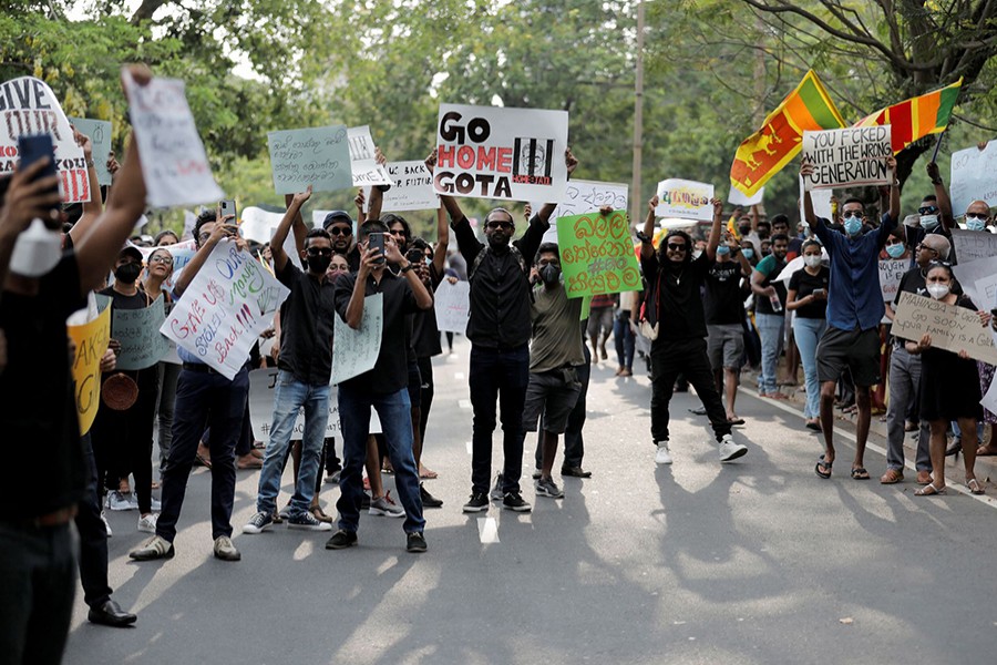 People carrying signs shout slogans against Sri Lanka's President Gotabaya Rajapaksa and demand that Rajapaksa family politicians step down, during a protest amid the country's economic crisis, on a main road in Colombo, Sri Lanka on April 4, 2022 — Reuters photo