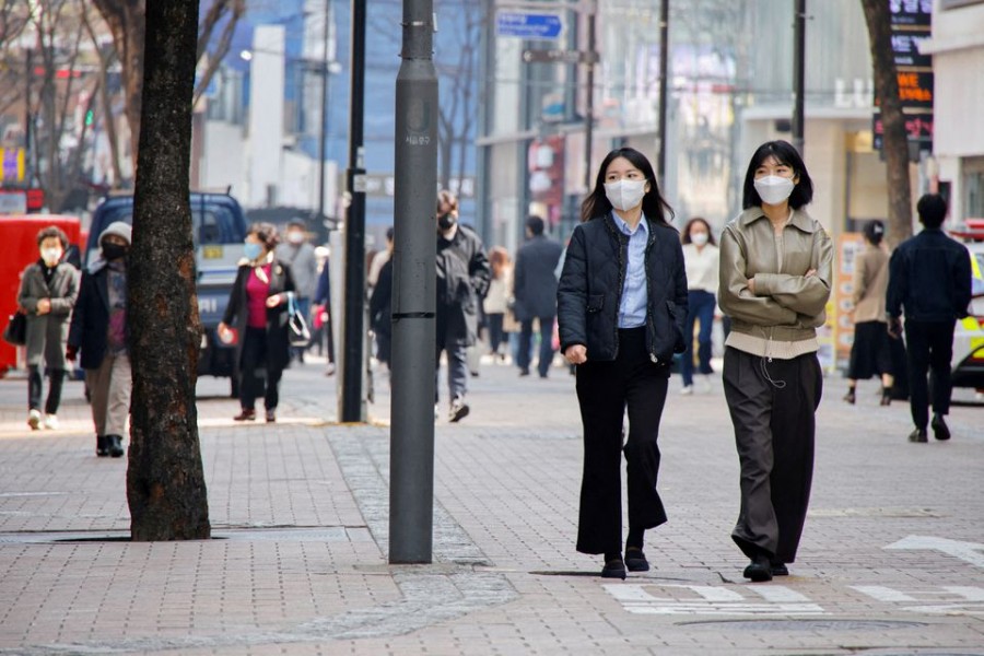 Women wearing masks walk in a shopping district amid the COVID-19 pandemic in Seoul, South Korea on March 16, 2022 — Reuters/Files