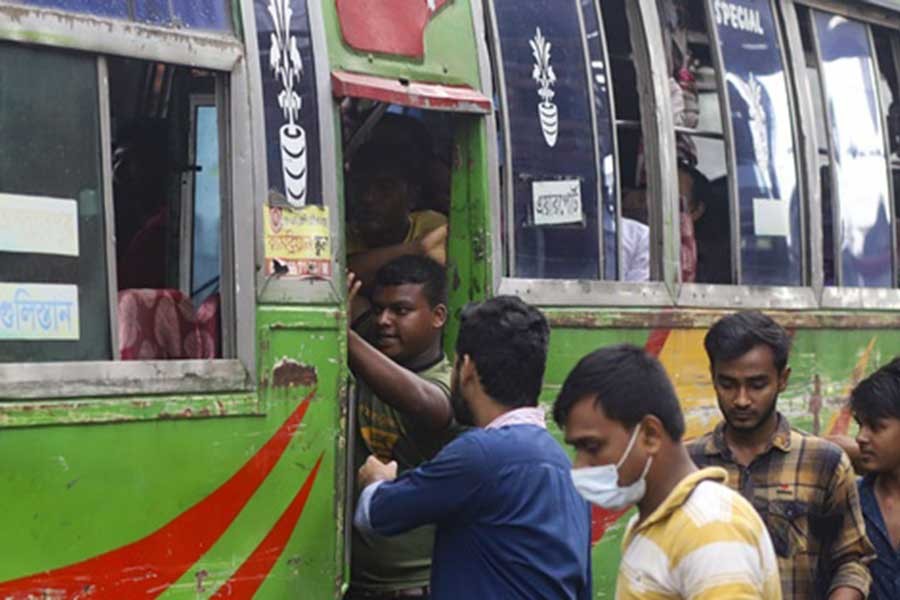 Passengers, many of them without a mask, scrambling to get on a bus in Dhaka’s Farmgate, as people’s respect for physical distancing and other health rules fade further along with a fall in new coronavirus cases –bdnews24.com file photo