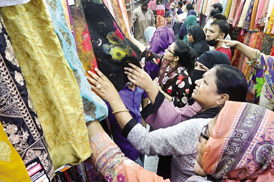 Shoppers busy making their choice of dresses at a shop in the city’s New Market area on Friday as Eid shopping gathers pace ahead of Eid-ul Fitr, a religious festival of the Muslims — FE photo by KAZ Sumon