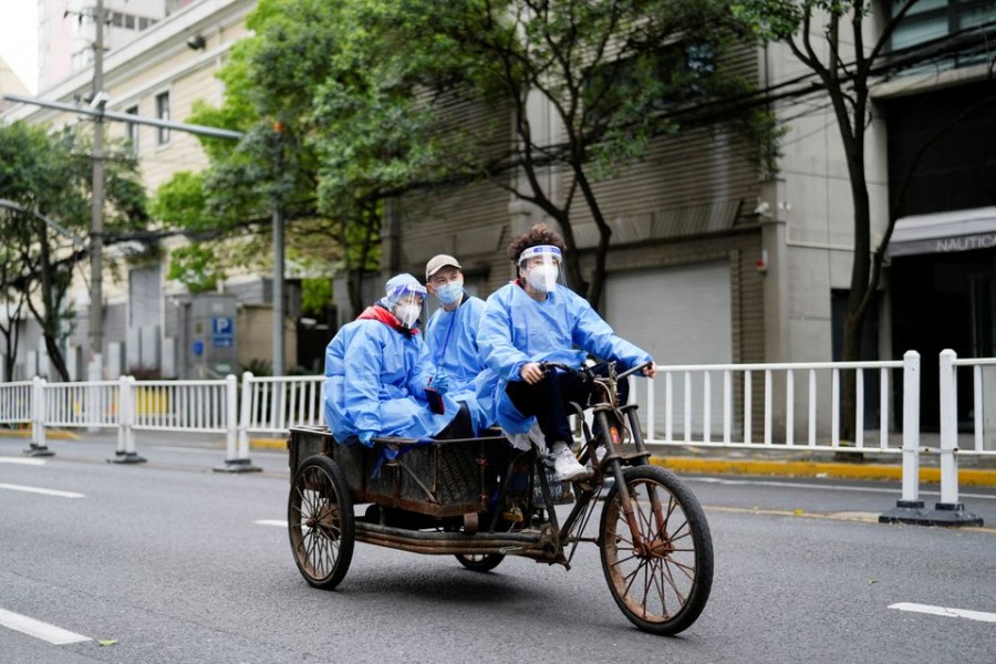 Workers in protective suits ride an electric tricycle during lockdown amid the coronavirus disease (Covid-19) pandemic, in Shanghai, China on April 15, 2022 — Reuters photo