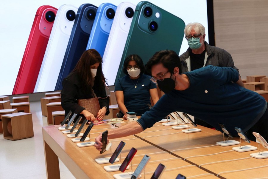 An employee arranges Apple iPhones as customer shop at the Apple Store on 5th Avenue shortly after new products went on sale in Manhattan, in New York City, New York, US, March 18, 2022. REUTERS/Mike Segar