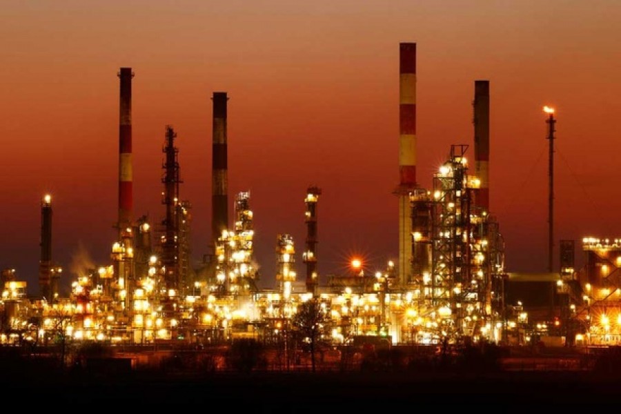 The chimneys of the Total Grandpuits oil refinery are seen just after sunset, southeast of Paris, France, March 1, 2021 — Reuters/Files