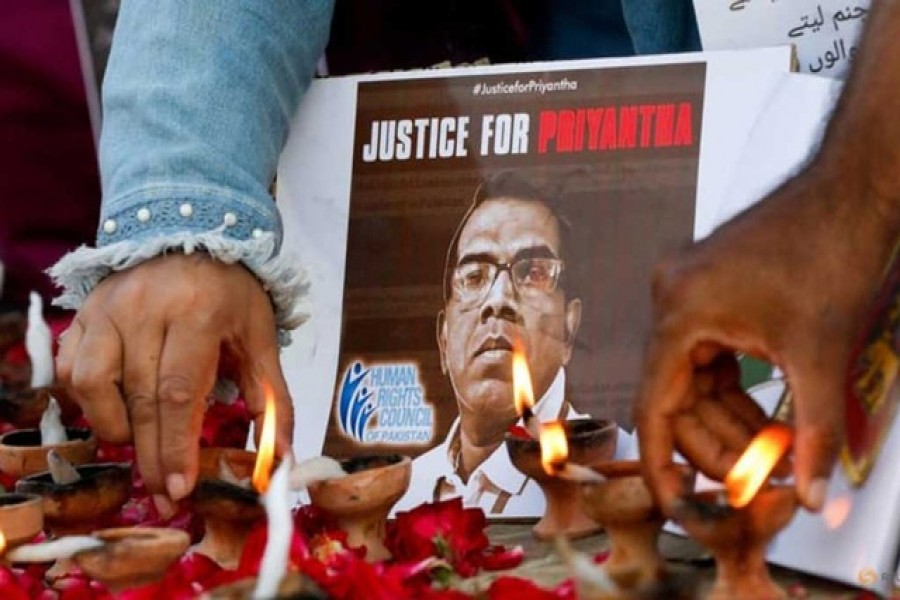 People light oil lamps next to laid roses to express their condolences to the people of Sri Lanka, following the lynching of the Sri Lankan manager of a garment factory after an attack on the factory in Sialkot, in Karachi, Pakistan, on Dec 5, 2021 – Reuters/Akhtar Soomro