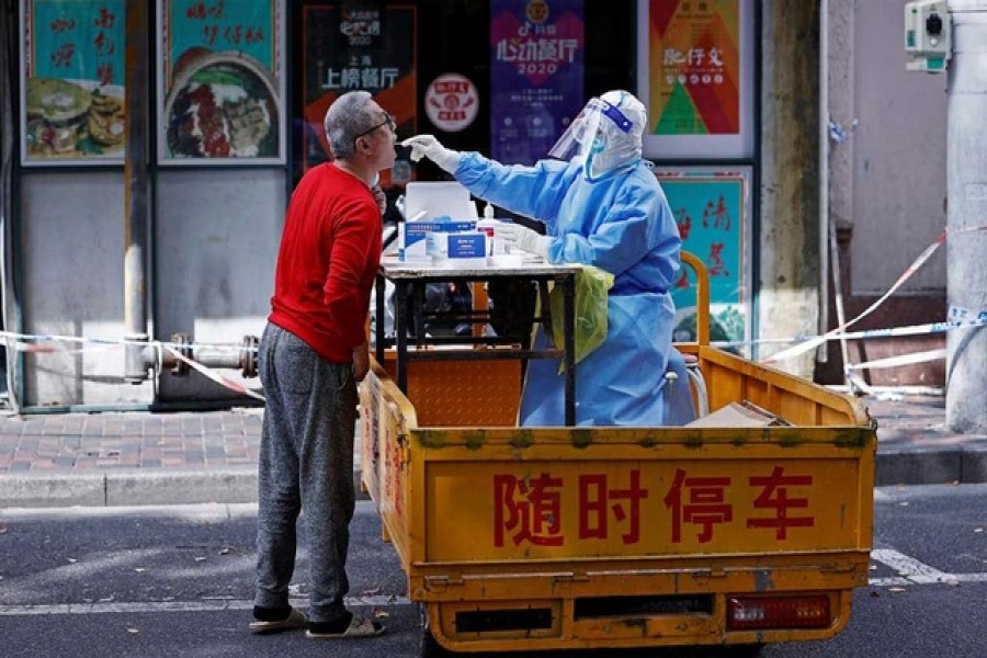 A medical worker in a protective suit collects a swab from a resident for nucleic acid testing, amid the coronavirus disease (COVID-19) outbreak in Shanghai, China Apr 22, 2022. REUTERS