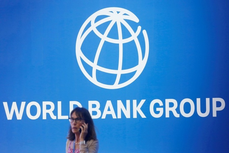 A participant stands near a logo of World Bank at the International Monetary Fund - World Bank Annual Meeting 2018 in Nusa Dua, Bali, Indonesia, October 12, 2018 – Reuters/Files