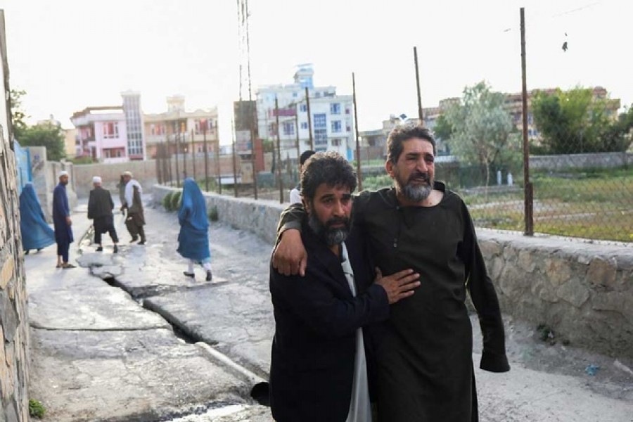 Afghan men flee near the site of explosions at Khalifa Sahib Mosque in Kabul, Afghanistan April 29, 2022. Reuters