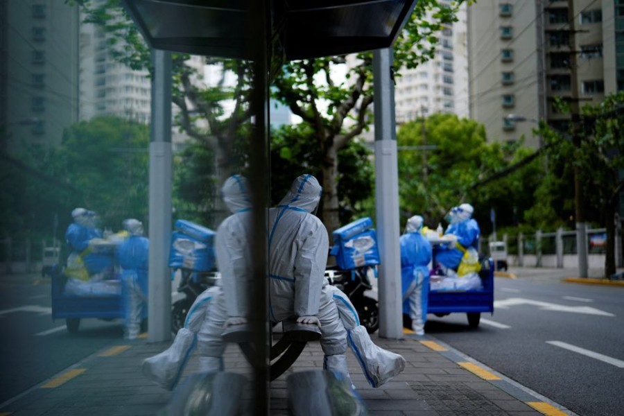 A worker in a protective suit keeps watch at a bus station during lockdown, amid the coronavirus disease (COVID-19) pandemic, in Shanghai, China, April 30, 2022. REUTERS/Aly Song