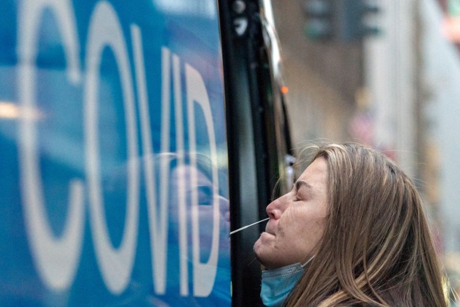 A woman takes a coronavirus disease (COVID-19) test at a pop-up testing site as the Omicron coronavirus variant continues to spread in Manhattan, New York City, US, December 27, 2021. REUTERS/Jeenah Moon