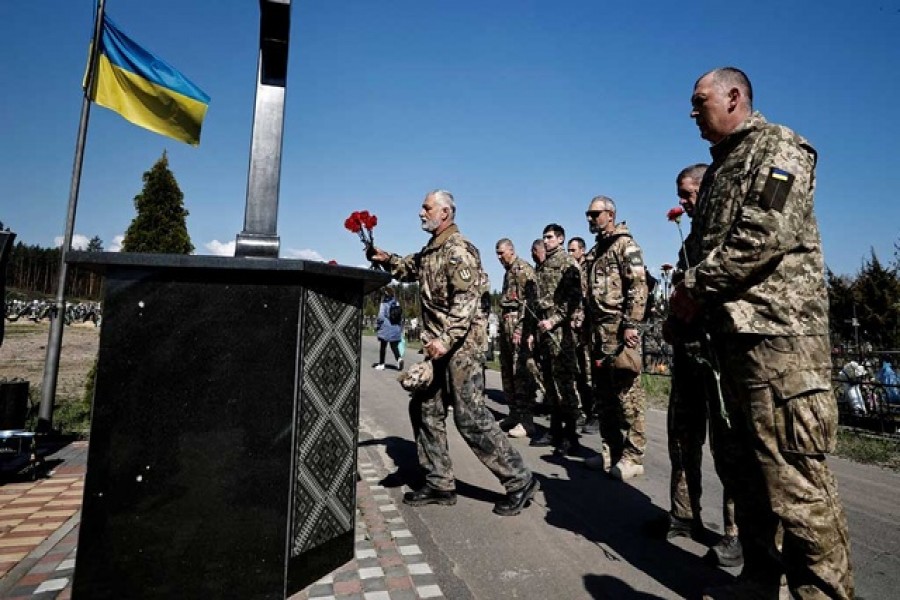 Members of Ukraine's Territorial Defence Forces arrive to honour fallen soldiers during the death memorial weekend which marks a week after the Orthodox Easter, amid the Russian invasion of Ukraine, at the cemetery in Irpin, outside Kyiv, Ukraine May 1, 2022. REUTERS/Zohra Bensemra