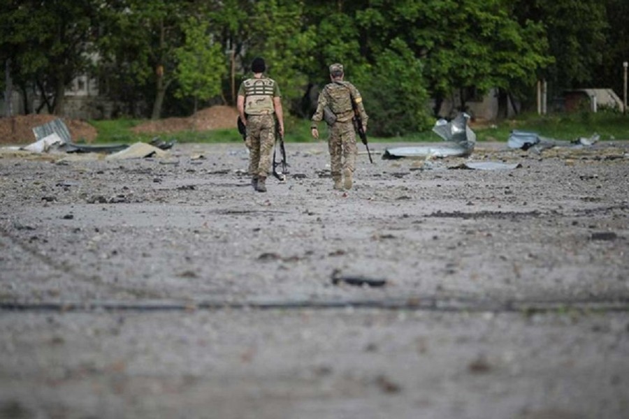 Ukrainian servicemen walk amidst rubble at a damaged area, as Russia's attack on Ukraine continues, in Kharkiv, Ukraine, May 14, 2022. REUTERS/Ricardo Moraes