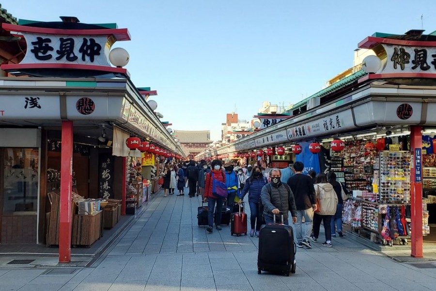 Tourists wearing protective face masks following an outbreak of the coronavirus disease (COVID-19) are seen at Asakusa district in Tokyo, Japan March 25, 2020. REUTERS/Ju-min Park/File Photo