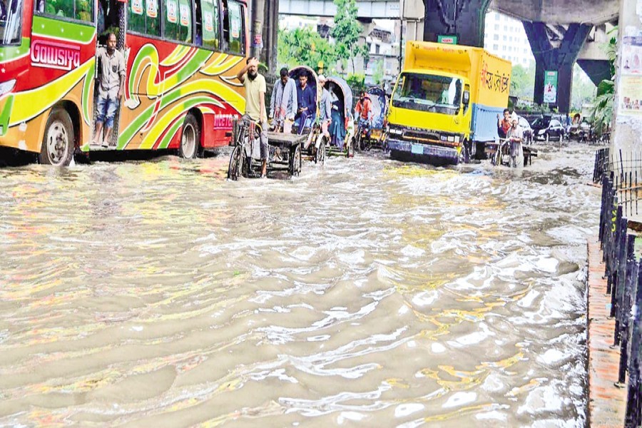 Vehicles driving through a waterlogged road in the Sholoshohor area of Chattogram city on Saturday. A couple of hours of downpour in the morning led to waterlogging in several parts of the port city, causing sufferings to its residents. — Focus Bangla