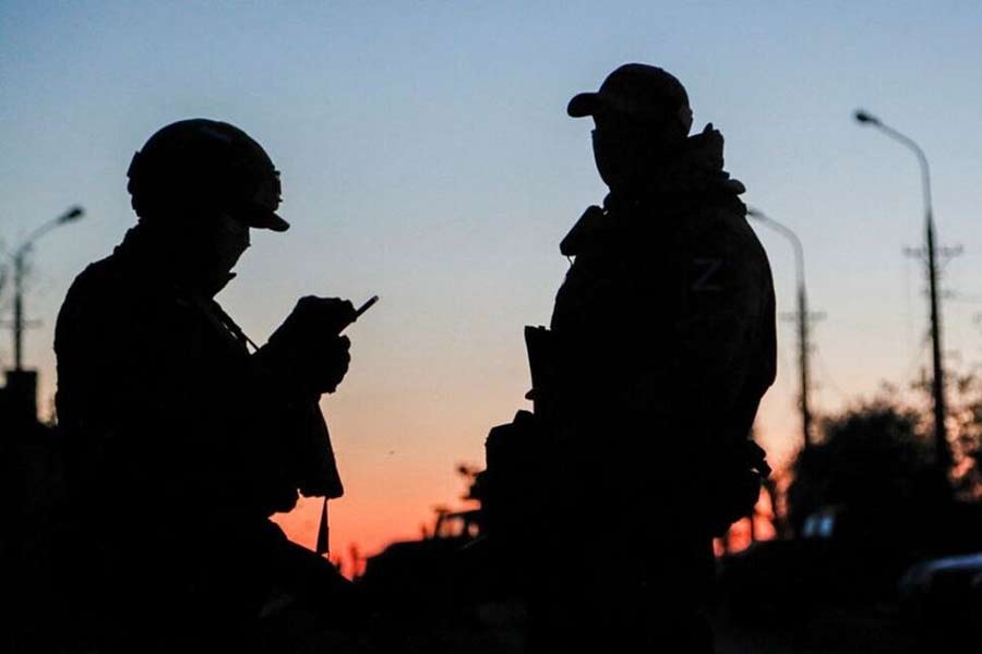 Russian service members standing guard on a road during sunset before the expected evacuation of wounded Ukrainian soldiers from the besieged Azovstal steel mill in the course of the Ukraine-Russia conflict in Mariupol of Ukraine on May 16 this year –Reuters file photo