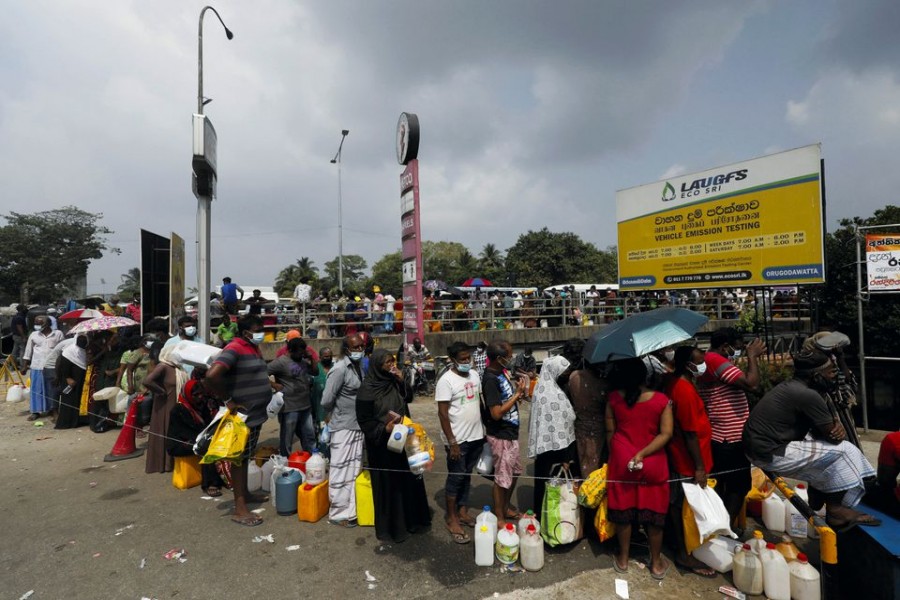 People stand in a long queue to buy kerosene oil due to shortage of domestic gas as a result of country's economic crisis, at a fuel station in Colombo, Sri Lanka March 18, 2022. REUTERS/Dinuka Liyanawatte