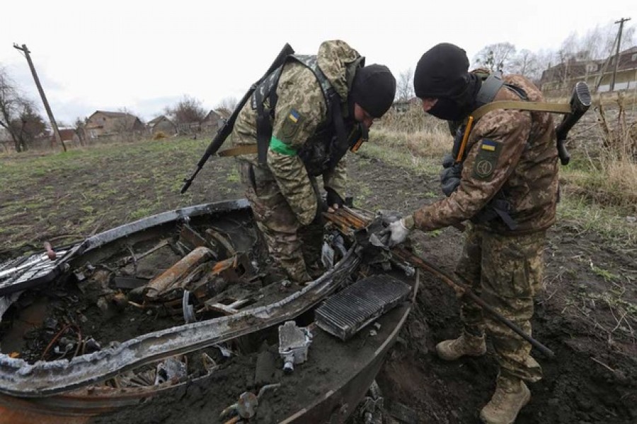 Military sappers dismount a machine gun from a Russian tank destroyed during Russia's invasion near the village of Motyzhyn, in Kyiv region, Ukraine April 10, 2022. REUTERS/Mykola Tymchenko