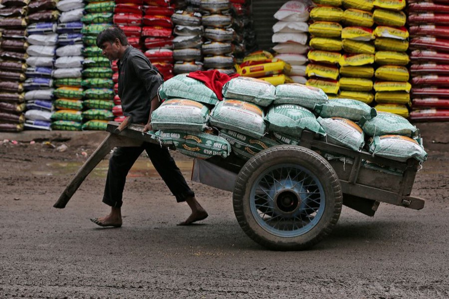 A labourer pulls a handcart loaded with sacks of lentils at a grain market in Ahmedabad, India on July 12, 2018 — Reuters/Files