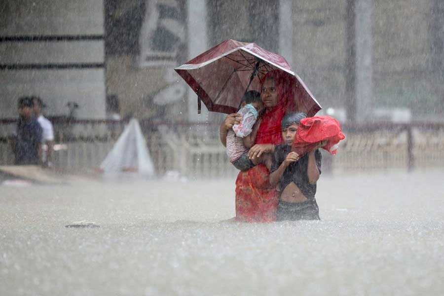 A woman, along with two children, looking for shelter during a flood, amidst heavy rains that caused widespread flooding in Sylhet –Reuters photo