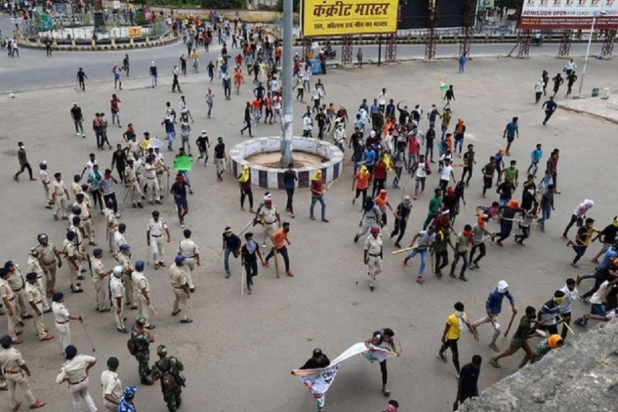 Protestors carry sticks as they enter a railway station during a protest against "Agnipath scheme" for recruiting personnel for armed forces, in Patna, in the eastern state of Bihar, India, June 17, 2022. REUTERS/Stringer