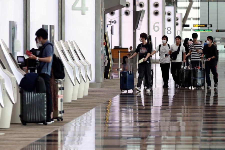 People wearing masks walk in Changi Airport, following the coronavirus outbreak, in Singapore March 5, 2020. REUTERS/Edgar Su