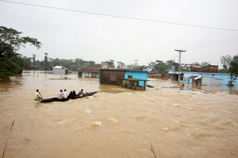 People move a boat in a flooded area during a widespread flood in the northeastern part of the country, in Sylhet, Bangladesh, June 19, 2022. REUTERS/Stringer