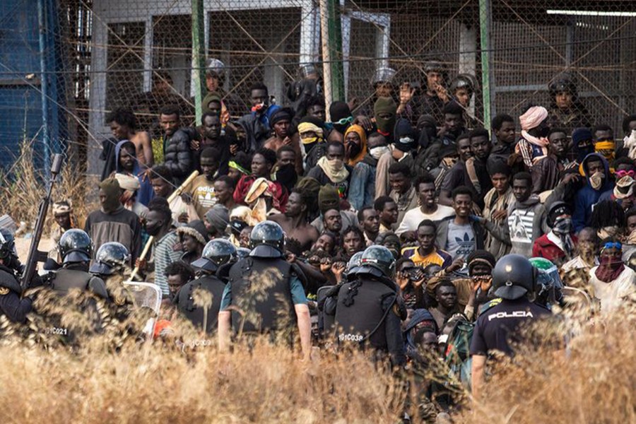 Riot police officers cordon off the area after migrants arrive on Spanish soil and crossing the fences separating the Spanish enclave of Melilla from Morocco in Melilla, Spain, Friday on June 24, 2022 — AP photo