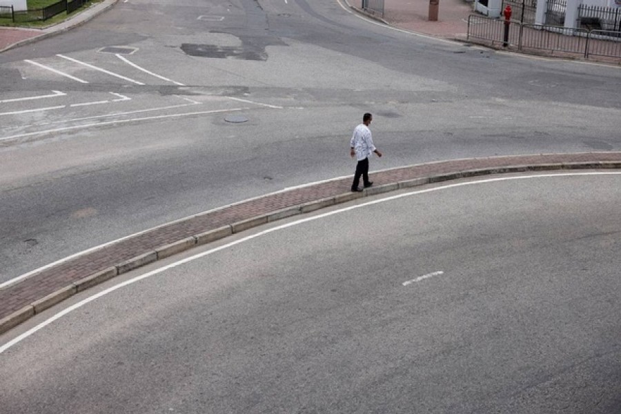 A man walks along main road as less vehicles are on the road due to fuel shortage, amid the country's economic crisis, in Colombo, Sri Lanka, Jun 28, 2022. REUTERS/Dinuka Liyanawatte