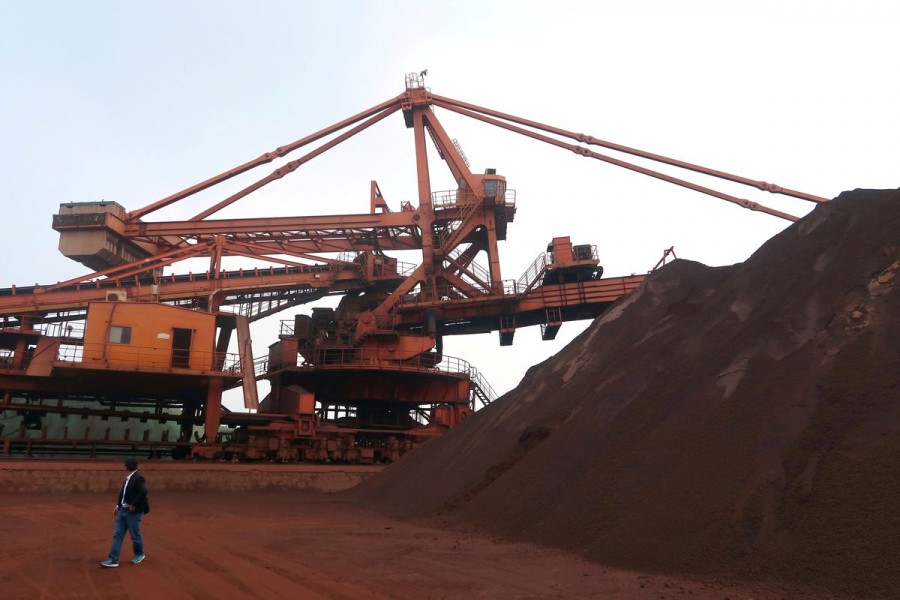 A man walks by an iron ore blending site at Dalian Port, Liaoning province, China September 21, 2018. Picture taken September 21, 2018. REUTERS/Muyu Xu/File Photo