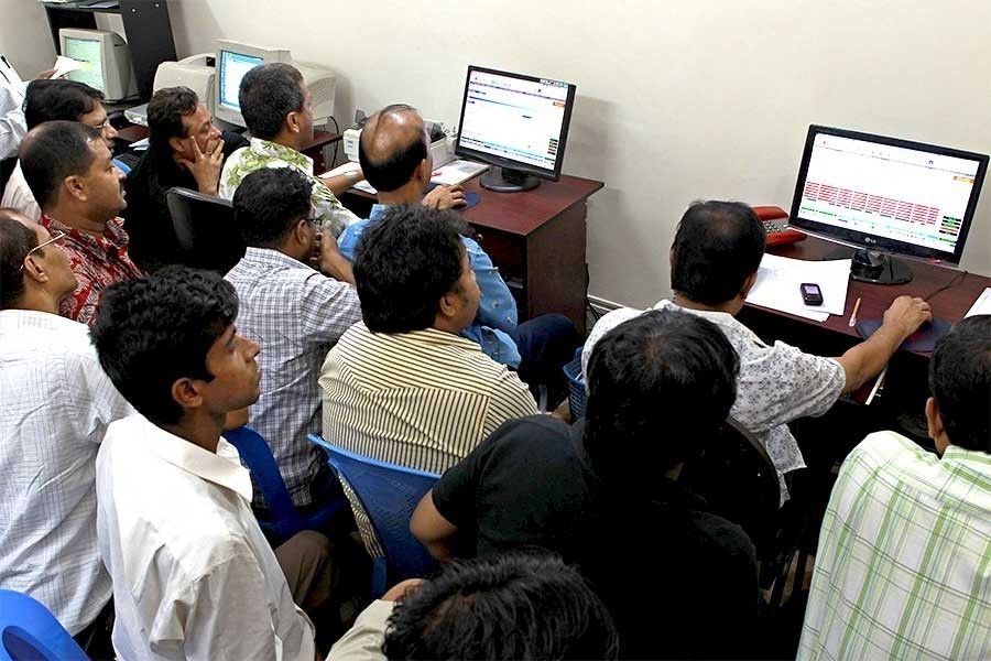 Investors react while monitoring stock price movements on computer screens at a brokerage house in the capital city — FE/Files