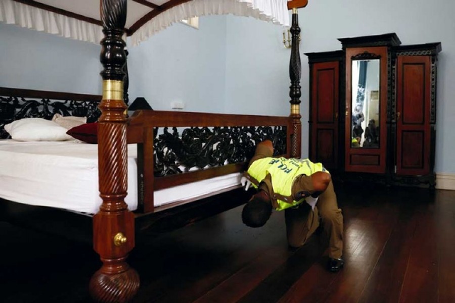 A police officer investigates inside the bedroom at the president's official residence after demonstrators vacated after a protest against Sri Lanka's former President Gotabaya Rajapaksa, amid the country's economic crisis, in Colombo, Sri Lanka, July 15, 2022. Reuters