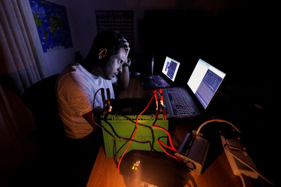 Amila Uduwerell, an IT officer who is home-based uses a car battery to charge his laptops as he works during the seven hours power outage, in Colombo, Sri Lanka on March 2, 2022 — Reuters/Files