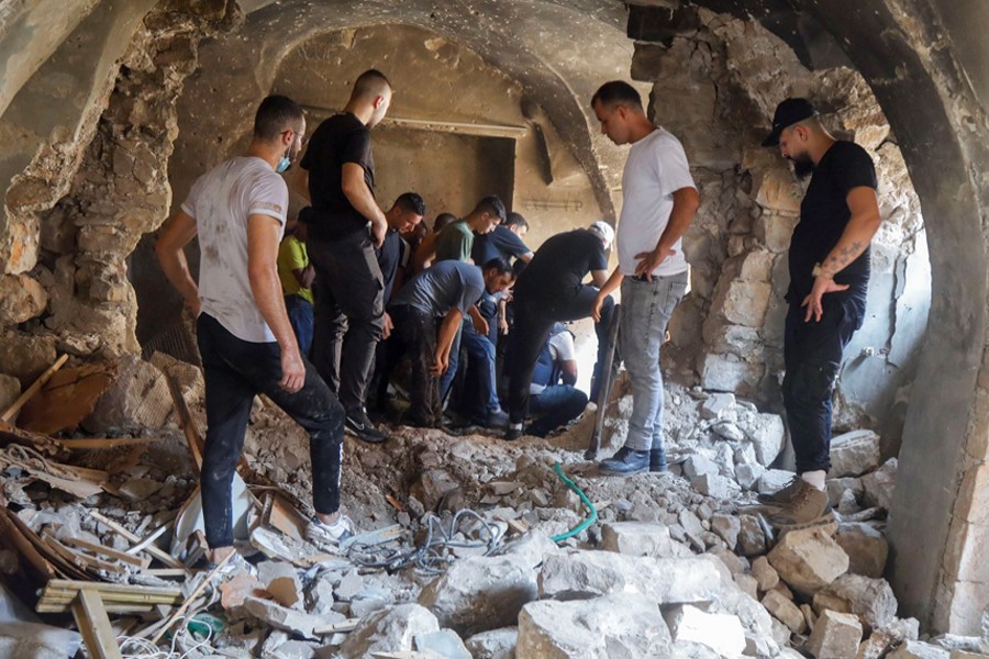 Palestinians inspect a building damaged during clashes between Palestinian militants and Israeli forces in a raid, in Nablus in the Israeli-occupied West Bank on August 9, 2022 — Reuters photo