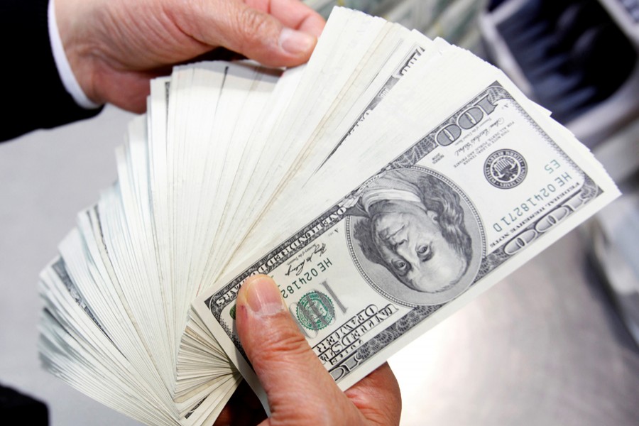 An employee of the Korea Exchange Bank counts one hundred US dollar notes during a photo opportunity at the bank's headquarters in Seoul on April 28, 2010 — Reuters/Files