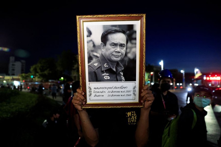 A person holds up a picture of Prime Minister Prayuth Chan-ocha during a protest by Thai political groups opposed to Prime Minister Prayuth Chan-ocha, near Government House, ahead of a Constitutional Court decision on when his eight-year PM terms ends, in Bangkok, Thailand August 23, 2022.REUTERS/Soe Zeya Tun