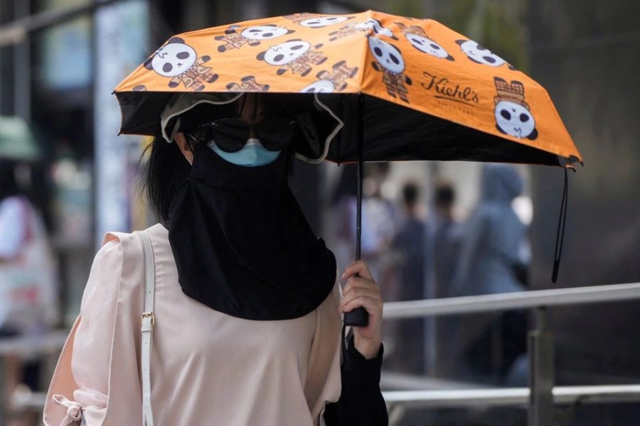 A woman wears a clothing that protect her from the sun, following the coronavirus disease (COVID-19) outbreak, amid a heatwave warning in Shanghai, China, August 23, 2022. REUTERS/Aly Song