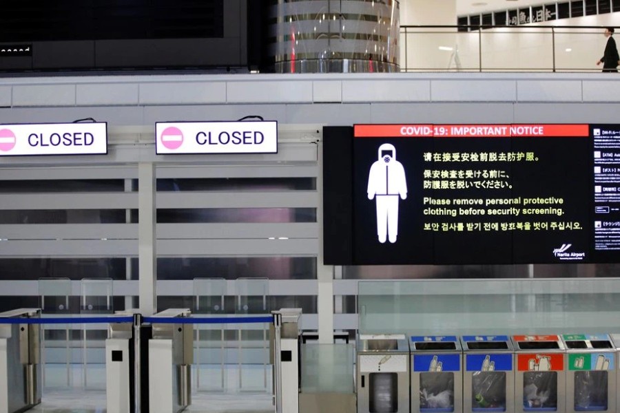 A notice about COVID-19 safety measures is pictured next to closed doors at a departure hall of Narita international airport on the first day of closed borders to prevent the spread of the new coronavirus Omicron variant in Narita, east of Tokyo, Japan, November 30, 2021. REUTERS/Kim Kyung-Hoon