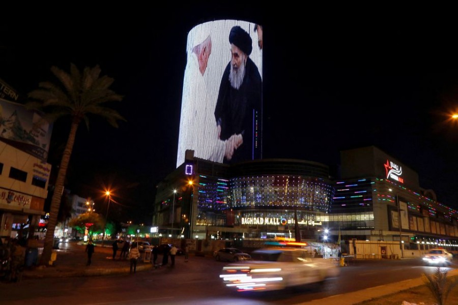 A building is illuminated with a picture of Pope Francis with Iraq's top Shi'ite cleric, Grand Ayatollah Ali al-Sistani, in Baghdad, Iraq March 7, 2021. REUTERS/Khalid al-Mousily/File Photo