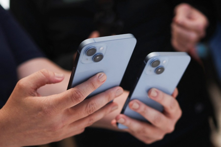 A guest holds the new iPhone 14 at an Apple event at their headquarters in Cupertino, California, US September 7, 2022. REUTERS/Carlos Barria