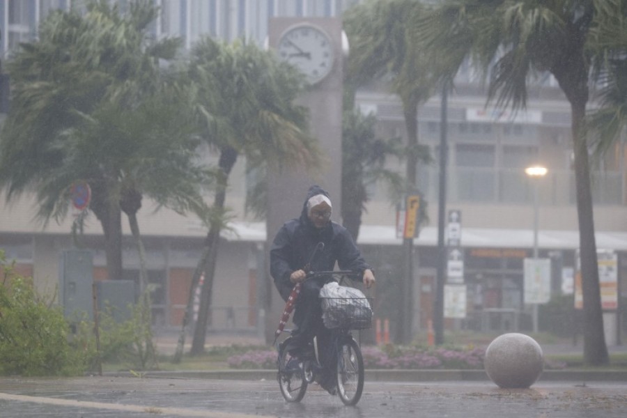 A man cycles past in the heavy rain and wind caused by Typhoon Nanmadol in Miyazaki on Japan's southernmost island of Kyushu September 18 [Kyodo via Reuters]