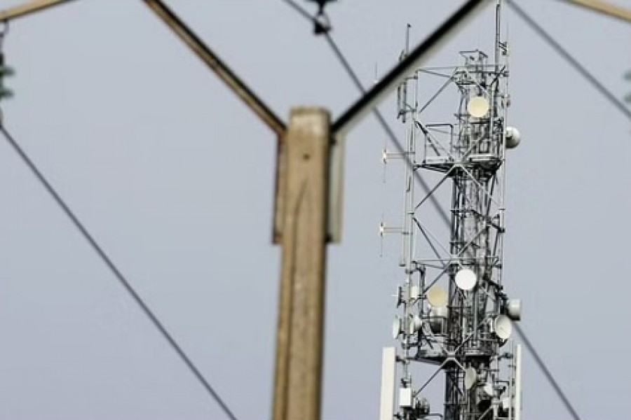 A mobile-phone relay mast is seen behind an electrical pylon in Tilloy-les-Cambrai, France, Sep 23, 2022. REUTERS