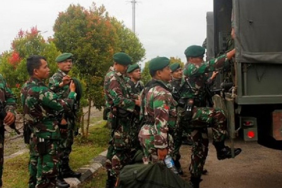 Indonesian soldiers get on to the vehicle as they arrive at Domine Eduard Osok Airport to be deployed to Sorong and Manokwari following the protests in Sorong, West Papua, Indonesia, Aug 20, 2019 REUTERS