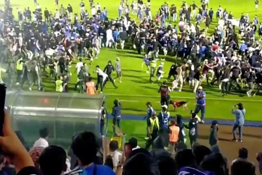 Fans invade the football field after a match between Arema FC and Persebaya Surabaya at Kanjuruhan Stadium, Malang, Indonesia Oct 2, 2022 in this screen grab taken from a REUTERS video. REUTERS TV via REUTERS