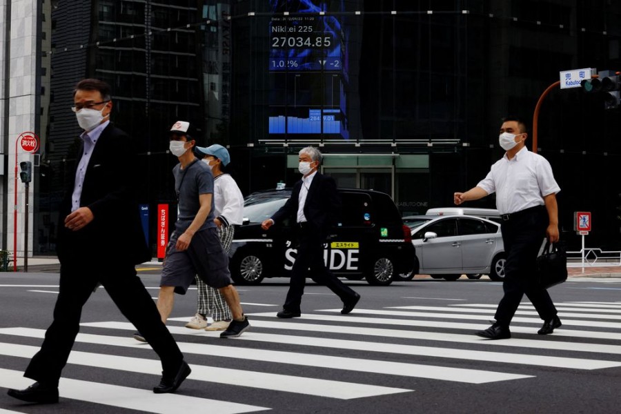 People pass by an electronic screen showing Japan's Nikkei share price index inside a commercial building in Tokyo, Japan September 22, 2022. REUTERS/Kim Kyung-Hoon