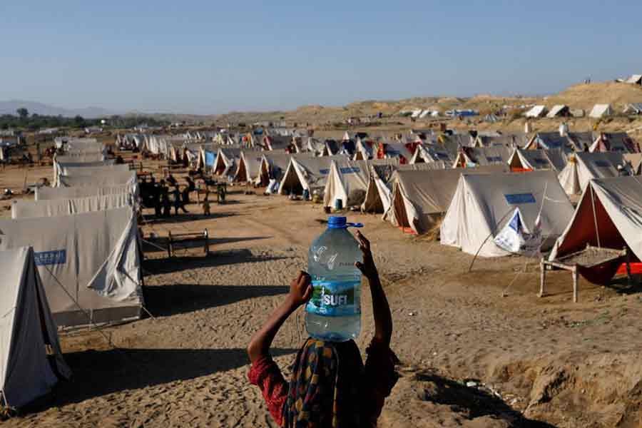 A displaced girl carrying a bottle of water from nearby stranded flood-waters near a refugee camp in Sehwan of Pakistan on September 30 this year –Reuters file photo