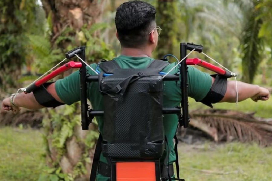 A research student Muhammad Haziq Ramli shows Terer, a robotic exoskeleton during a testing of the prototype at a palm oil plantation in Yong Peng, Johor, Malaysia, Sept 8, 2022. REUTERS